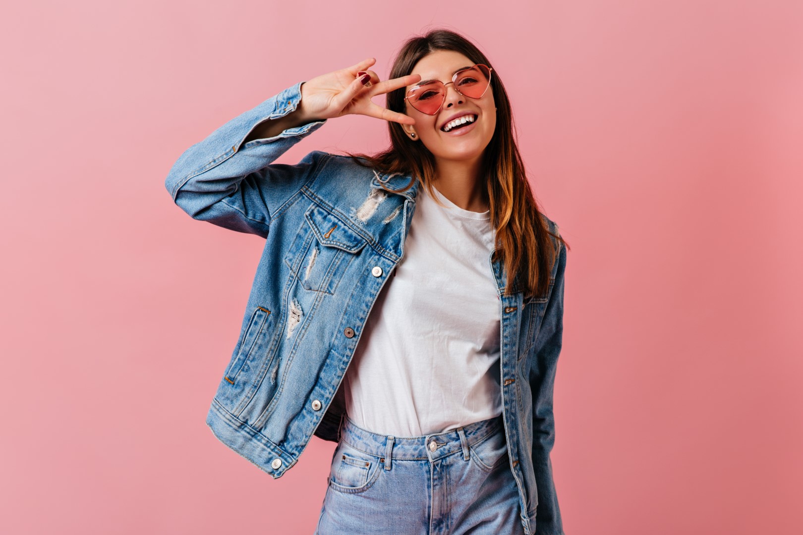 Cheerful young woman showing peace sign with smile